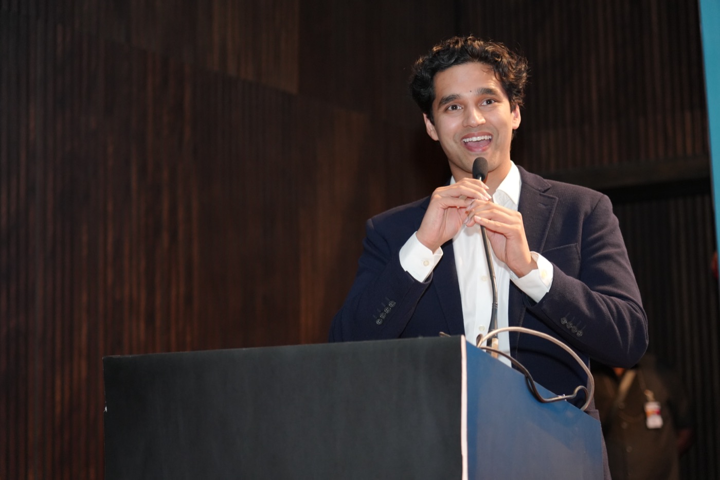Sudhanshu speaking at a podium