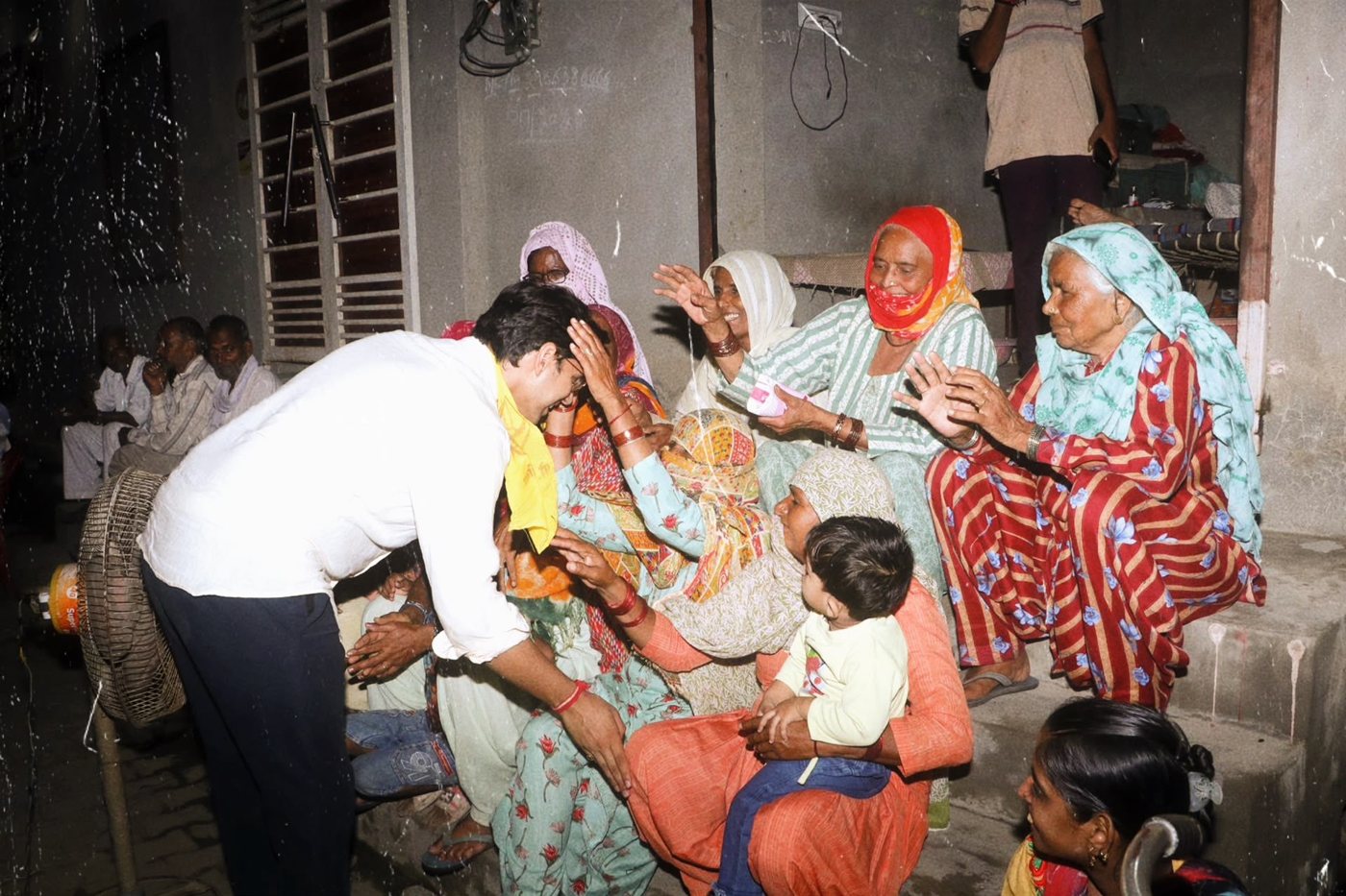 Sudhanshu greeting women elders on a village doorstep at night
