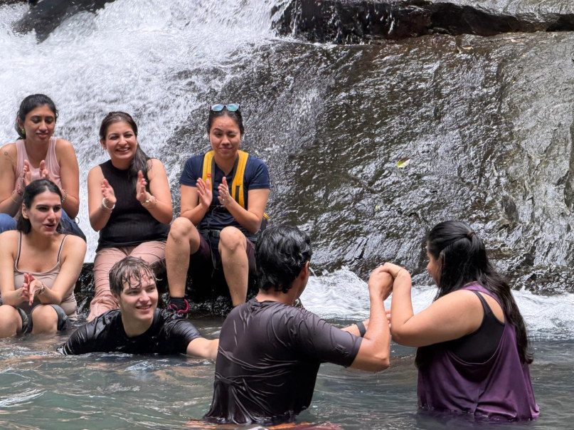 Delegates together at a waterfall