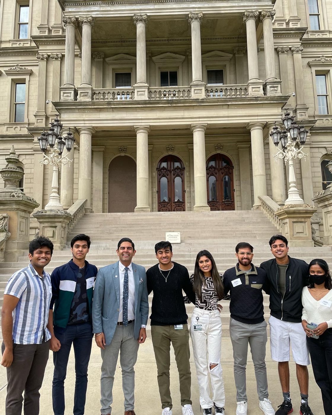 NAAIS students with a legislator on the Michigan Capitol steps